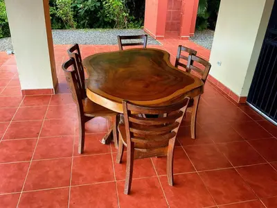 a wooden table and chairs sitting on a patio at Casa Nekori Wonderful Mountain view 15 minutes from Samara in Nicoya