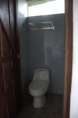 a bathroom with a white toilet in a room at Village Río Celeste, Eco Lodge and Tours in Rio Celeste