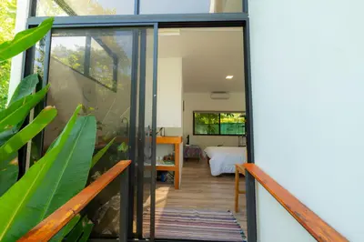 a glass door leading into a room with a bedroom at Modern studio near Santa Teresa beach in Boca de Ario