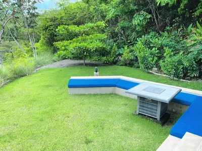a garden with a blue bench in the grass at Villa Hermanos Luxury Home with Ocean View in Sámara