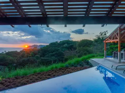 a house with a swimming pool with a view of the ocean at Villa Hermanos Luxury Home with Ocean View in Sámara