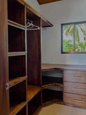 a closet with wooden shelves and a desk at Villa Hermanos Luxury Home with Ocean View in Sámara