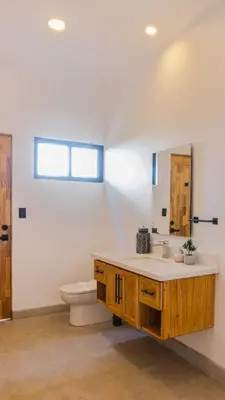 a bathroom with a sink and a toilet and a mirror at Casa Jurassic Amazing villa 10 min walk to the beach in Sámara