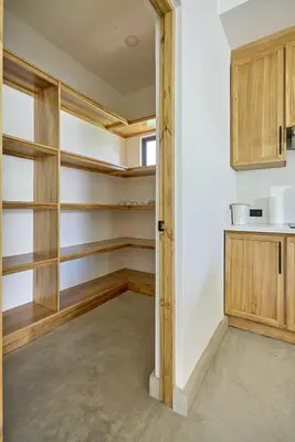 a kitchen with wooden shelves in a room at Casa Cretaceous Modern villa 10 min walk to the beach in Sámara