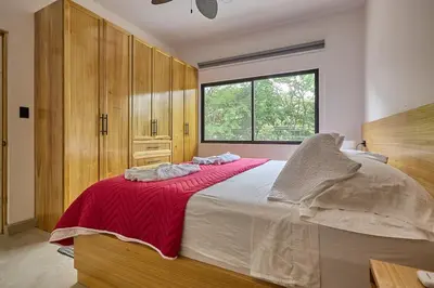 a bedroom with a large bed with a red blanket at Casa Cretaceous Modern villa 10 min walk to the beach in Sámara