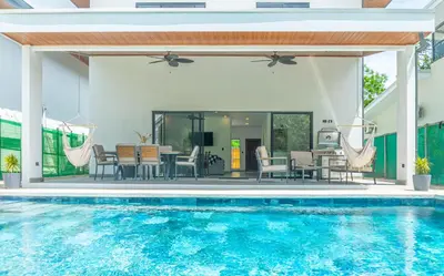 an outdoor patio with a swimming pool and a house at Casa Cretaceous Modern villa 10 min walk to the beach in Sámara
