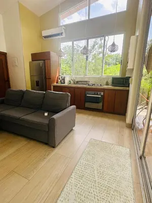 a living room with a couch and a kitchen at Casa Hilltop Peaceful house 15 minutes from Samara in Sámara