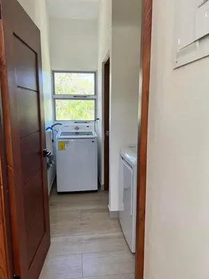 a laundry room with a refrigerator and a window at Casa Hilltop Peaceful house 15 minutes from Samara in Sámara