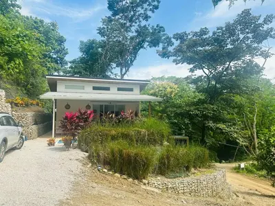 a small house with a car parked in front of it at Casa Hilltop Peaceful house 15 minutes from Samara in Sámara