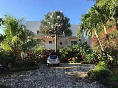 a car parked in front of a building with palm trees at Casa Blanca #1 Beautiful modern beach house in Sámara