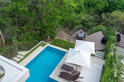 an aerial view of a swimming pool with chairs and umbrellas at Casa Blanca #1 Beautiful modern beach house in Sámara