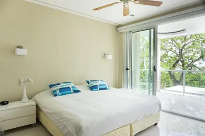 a bedroom with a bed with blue pillows on it at Casa Blanca #1 Beautiful modern beach house in Sámara
