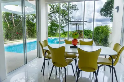 a dining room with a white table and yellow chairs at Casa Blanca #1 Beautiful modern beach house in Sámara
