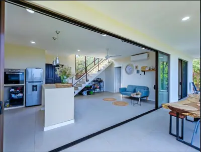 a kitchen and living room with a large glass window at Casa Flores Ocean view 10 min to Carrillo in Sámara