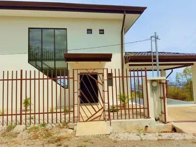 a small house with a gate and a fence at Casa Flores Ocean view 10 min to Carrillo in Sámara
