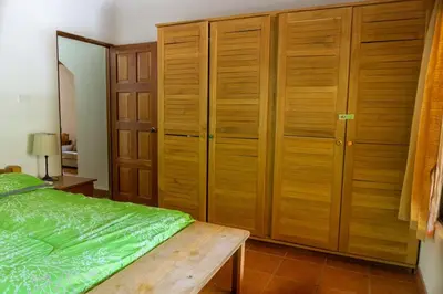 a bedroom with wooden cabinets and a green bed at Casa Francesca Beautiful house with a large garden in Sámara