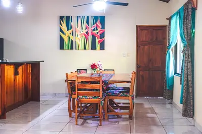 a dining room with a wooden table and chairs at Aloha Surf Nosara - Casa 'Ohana in Nosara