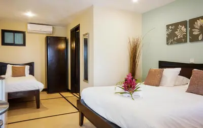 a hotel room with two beds with flowers on it at Casa Marbella in Santa Teresa Beach