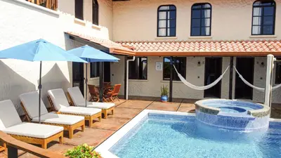 a pool with chairs and umbrellas next to a house at Casa Marbella in Santa Teresa Beach