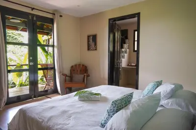 a bedroom with a bed and a sliding glass door at Casa Marbella in Santa Teresa Beach