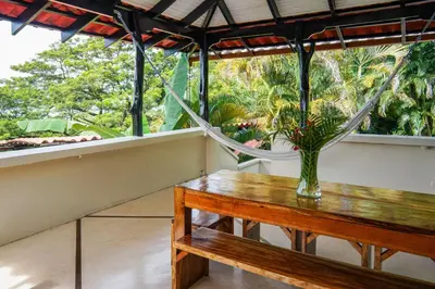 a vase of flowers on a table on a balcony at Casa Marbella in Santa Teresa Beach