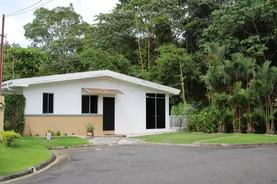 a white house with a driveway in front of it at Bamboo House in Herradura with private pool in Herradura