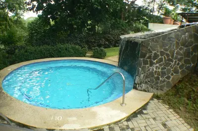 a small blue pool with a hose in a yard at Bamboo House in Herradura with private pool in Herradura