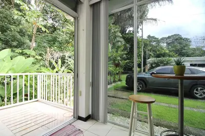 a screened porch with a table and a view of a car at Bamboo House in Herradura with private pool in Herradura