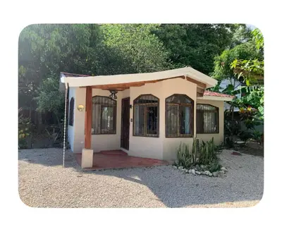 a small house with a door in a yard at Oceana Breeze Perfect Getaway steps from the beach in Sámara