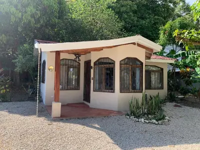 a small house with a door in a yard at Oceana Breeze Perfect Getaway steps from the beach in Sámara
