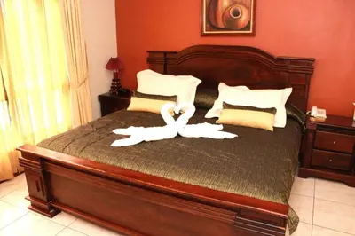 a bedroom with a bed with two white towels at Sportsmens Lodge - Gentlemen's Club in San José
