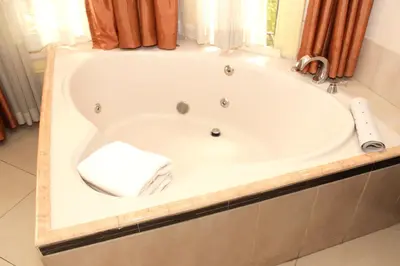 a bath tub with a towel in a bathroom at Sportsmens Lodge - Gentlemen's Club in San José