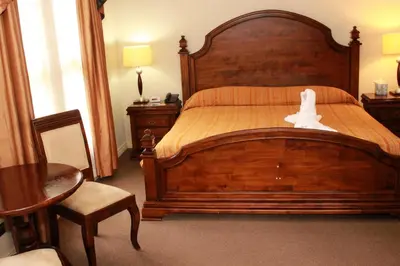 a bedroom with a large wooden bed with a white bird on it at Sportsmens Lodge - Gentlemen's Club in San José