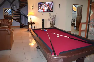 a billiard table in a living room with at Sportsmens Lodge - Gentlemen's Club in San José
