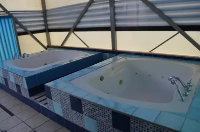 two jacuzzi tubs in a room with blue tiles at Sportsmens Lodge - Gentlemen's Club in San José