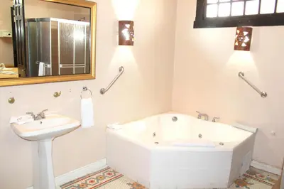 a bathroom with a bath tub and a sink at Sportsmens Lodge - Gentlemen's Club in San José