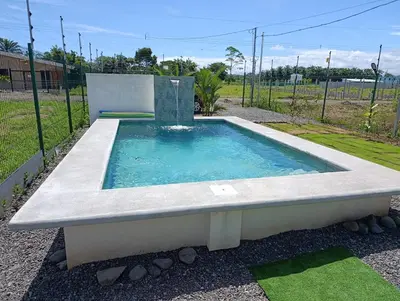 a swimming pool with a fountain in a yard at Maracuyá Garden Stanza 2 in Parrita
