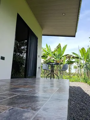 an outdoor patio with a table and chairs in a house at Maracuyá Garden Stanza 2 in Parrita