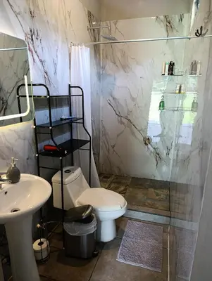 a bathroom with a toilet and a sink and a shower at Maracuyá Garden Stanza 2 in Parrita