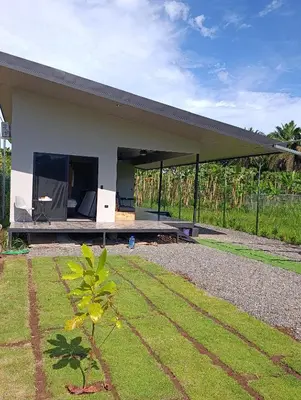 a house with a patio and a grass yard at Maracuyá Garden Stanza 2 in Parrita
