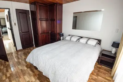 a bedroom with a bed with two pillows on it at Tico Airport B&B in Alajuela City