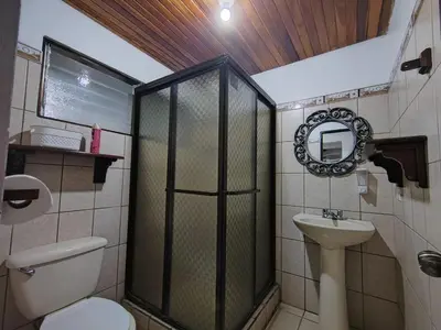 a bathroom with a shower and a toilet and a sink at Tico Airport B&B in Alajuela City