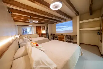a bedroom with two beds and a large screen at Toro by Dreamcatcher in Santa Teresa Beach