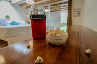 a red drink and a bowl of popcorn on a wooden table at Toro by Dreamcatcher in Santa Teresa Beach