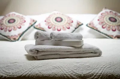 a pile of towels sitting on a bed with pillows at Toro by Dreamcatcher in Santa Teresa Beach