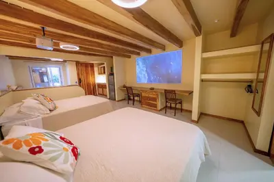 a bedroom with two beds and a flat screen tv at Toro by Dreamcatcher in Santa Teresa Beach