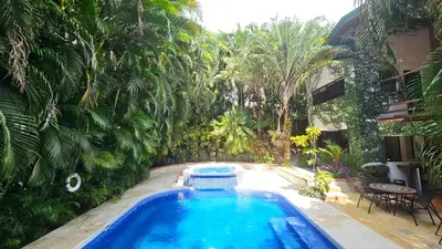 a swimming pool in a yard with palm trees at Toro by Dreamcatcher in Santa Teresa Beach