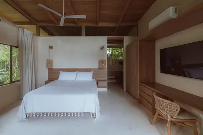 a bedroom with a bed and a flat screen tv at Casa Solomia Luxury Oceanview 5 min to the Beach in Mal País