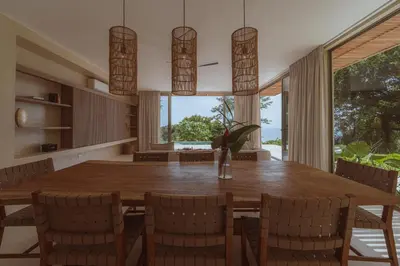a dining room with a large wooden table and chairs at Casa Solomia Luxury Oceanview 5 min to the Beach in Mal País