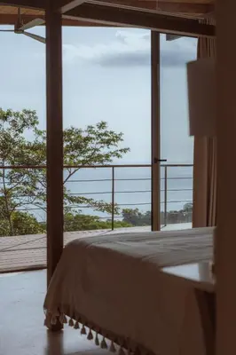 a bedroom with a bed and a large window at Casa Solomia Luxury Oceanview 5 min to the Beach in Mal País